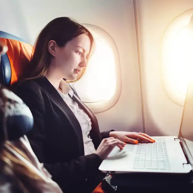 Businesswoman working on a laptop on a plane