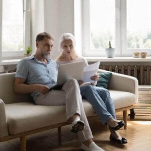 A couple on the couch comparing car insurance on a laptop.