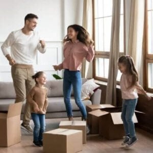 Exciting family in a new home with packed boxes on the floor.