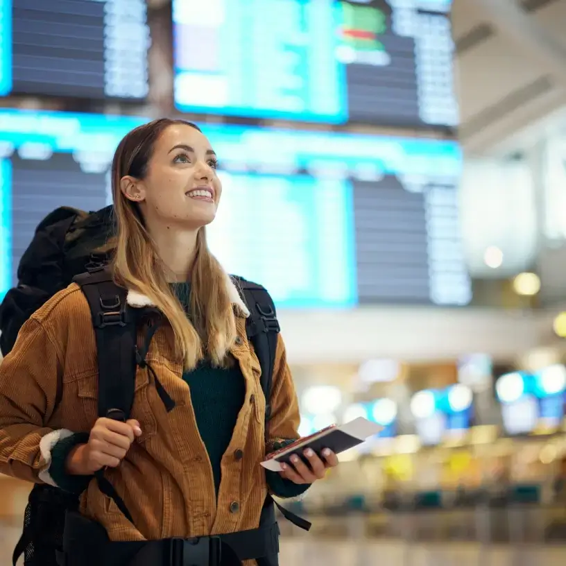 Female traveller at airport with one-way travel insurance
