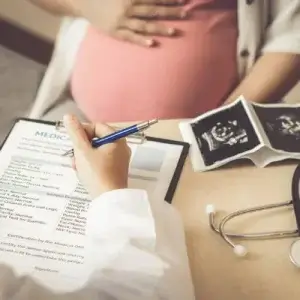 Pregnant woman with doctor checking she can travel