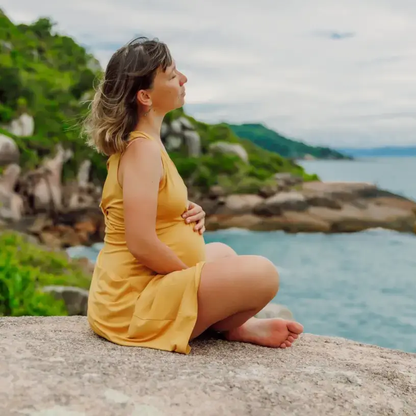 Pregnant woman with travel insurance on holiday by the ocean