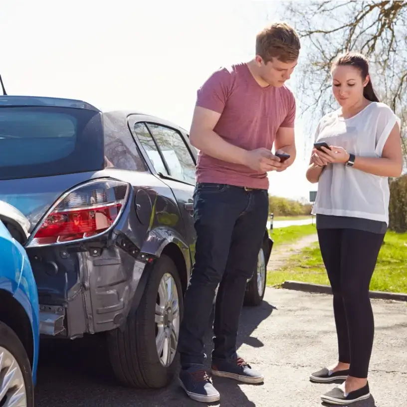 A man and a woman exchange contact details after a car accident.