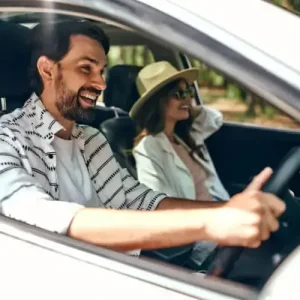 A man driving with a woman in the passenger seat.