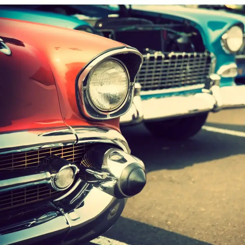 Two classic cars in a car park