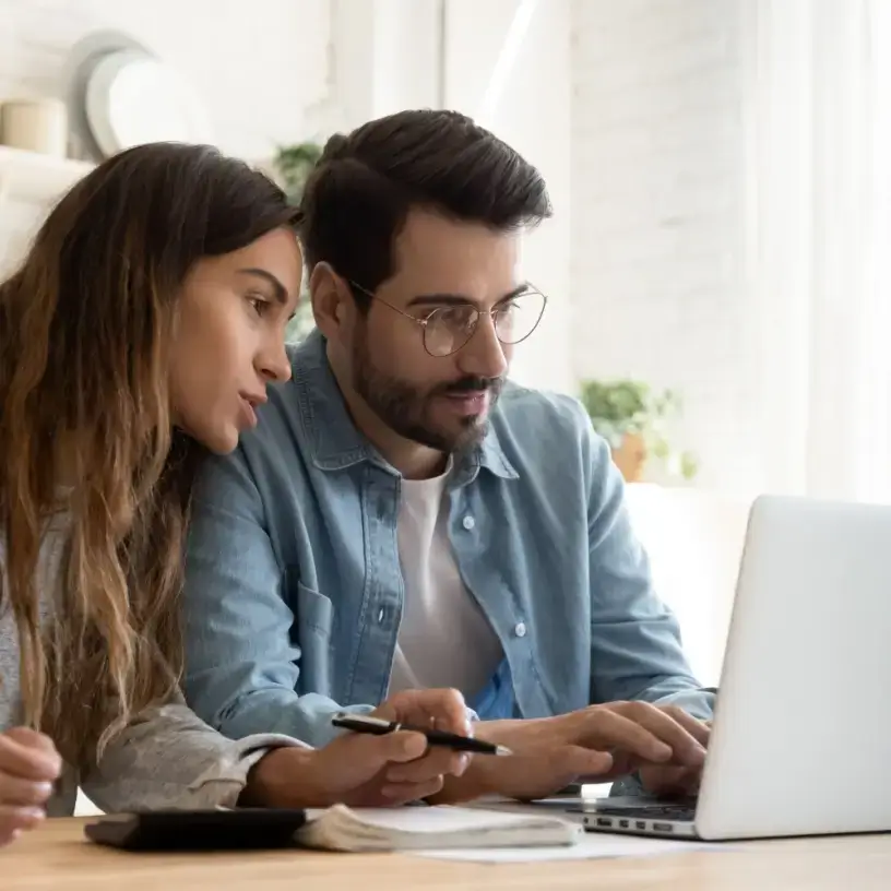 A couple on a laptop, comparing car insurance online