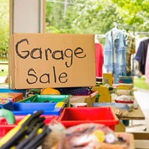 A cluttered table with a sign reading "garage sale".