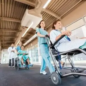 patient being pushed on a wheelchair by a female nurse