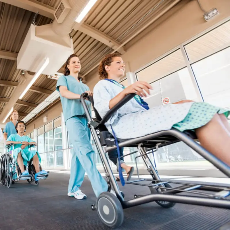 patient being pushed on a wheelchair by a female nurse