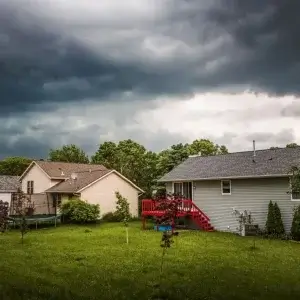 Storm clouds over two suburban houses.