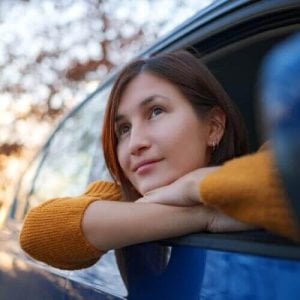 A woman in blue car.