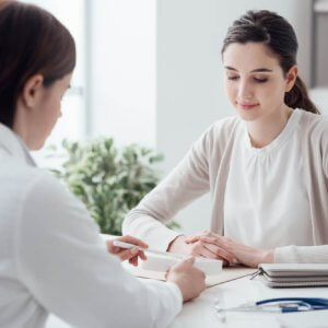 Woman with a pre existing conditions talking to doctor