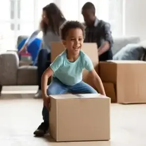 Married couple and child unpacking moving boxes