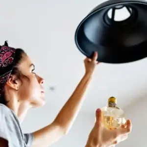Woman who is changing a lightbulb