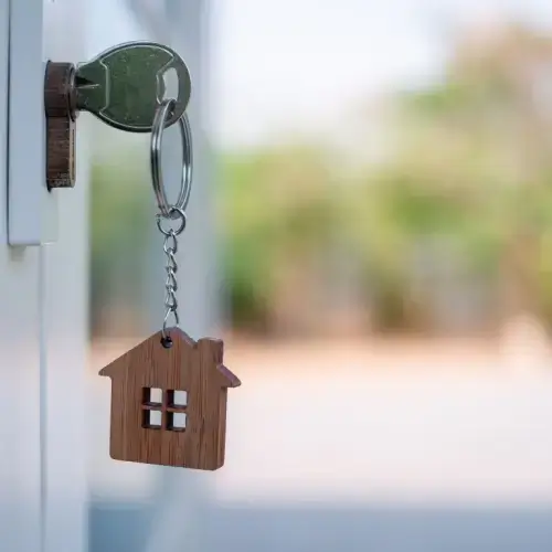 Key sitting in door of house with landlord insurance