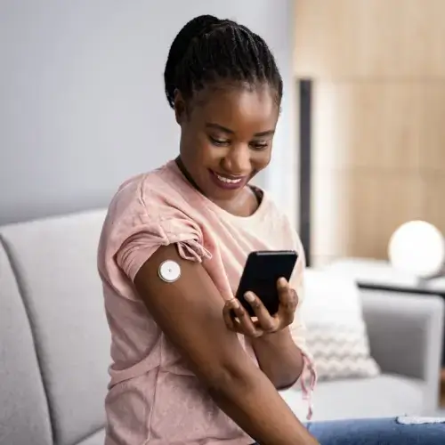 Woman using her CGM device