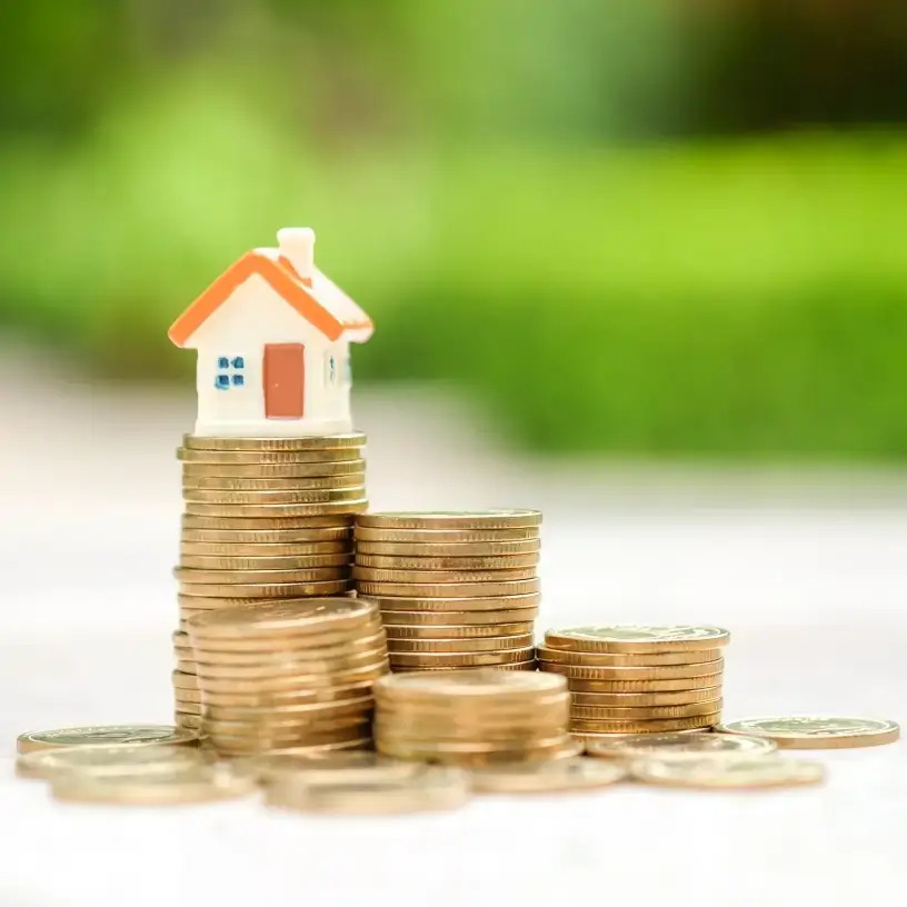 mini house sitting on coins