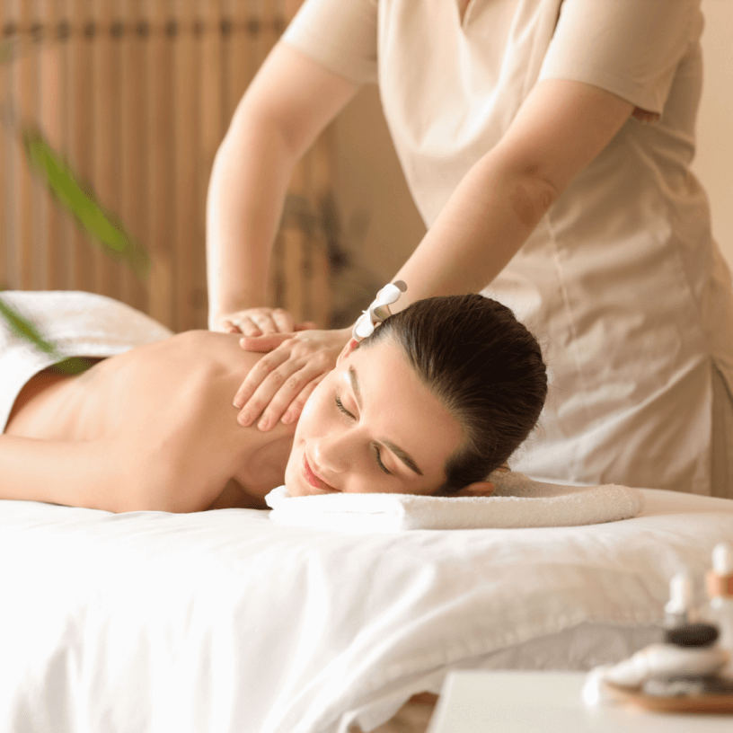 Young woman getting back massage on couch in spa salon