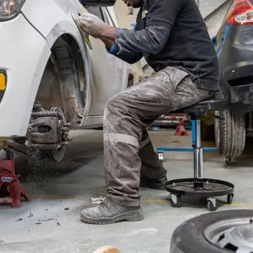 Panel beater working on car