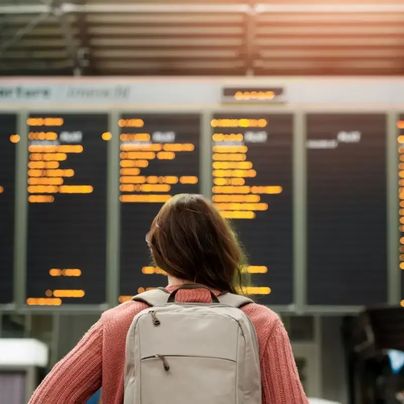 Woman looking at flight schedule at airport