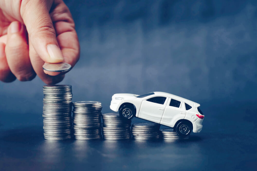 toy car on coins representing car insurance excess