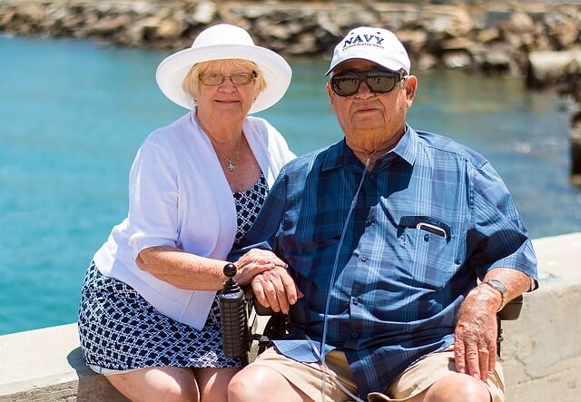 senior man in a wheelchair with a older wom