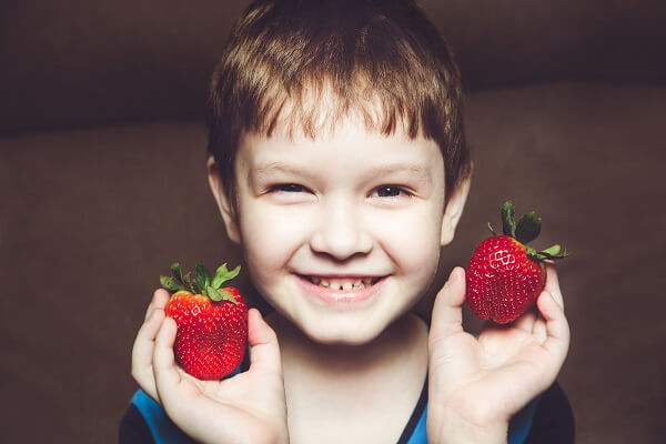child holding strawberries