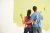 couple painting a wall green