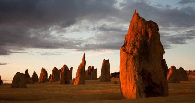 Limestone formations glowing red at last light in the Pinnacles desert in Nambung National Park, Western Australia