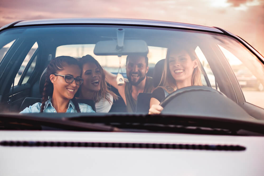 Group of friends driving while protected by car insurance for young drivers