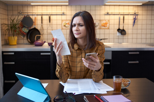 woman paying electricity bills in kitchen