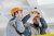 Two electricians install new energy efficient lighting in the roof of a small business.