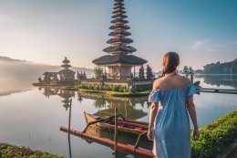 Woman near Pura Ulun Danu Bratan temple in Bali island, Indonesia at sunrise