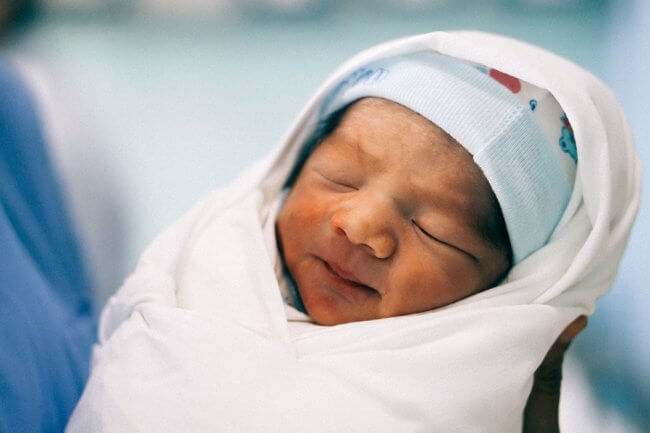 a newborn baby wrapped in a swaddle