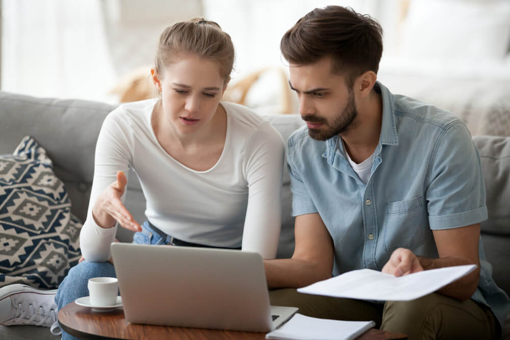 A young couple searching for a cheaper home insurance policy.