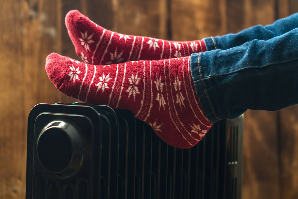 Close up of woman in red socks resting her feet on heater