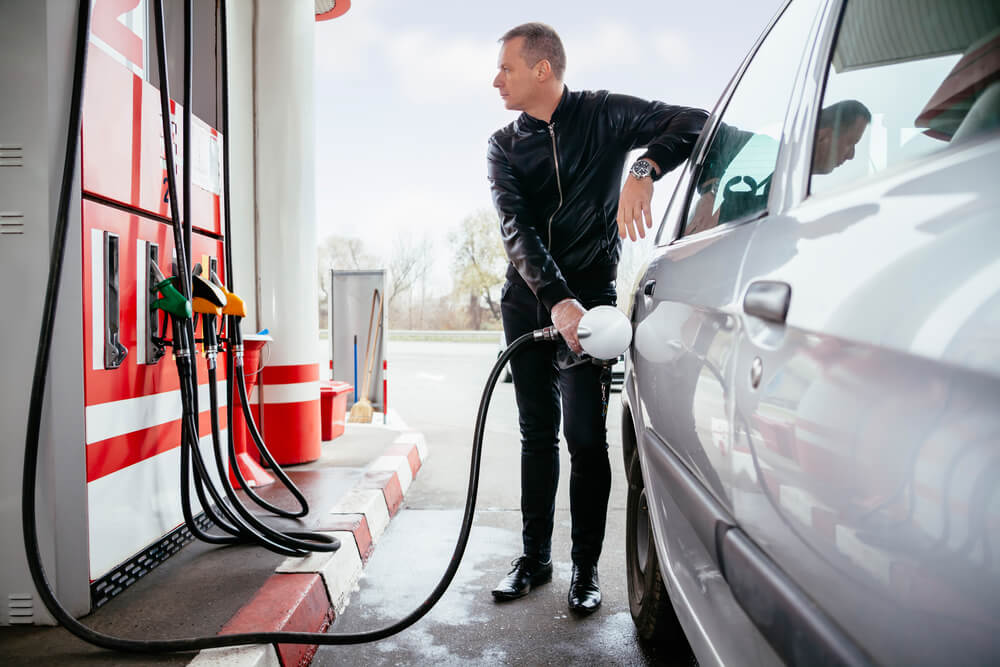 A man filling up his car fuel tank with petrol