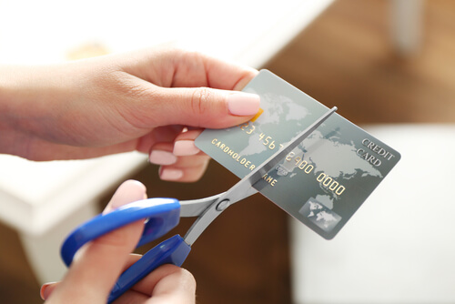 close up of a woman cutting a credit card