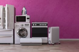 A collection of household appliances against a pink wall