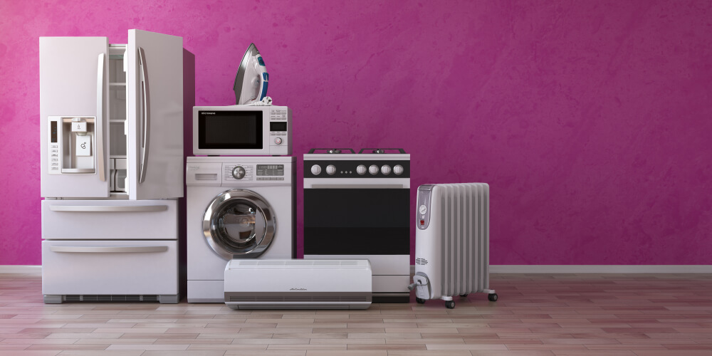 A collection of household appliances against a pink wall