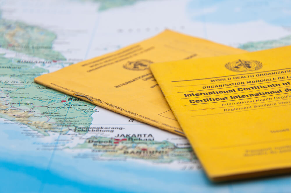 travel vaccination certificates lying on a map