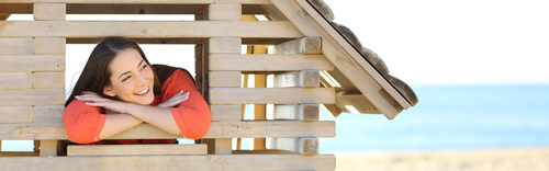 a woman in a wooden toy house on the beach