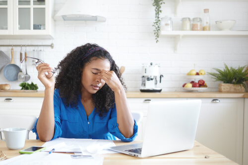 a woman paying bills in the kitchen