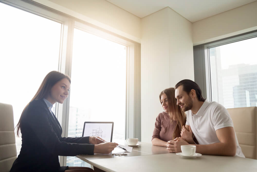 A couple preparing their rental application with guidance from real estate agent.