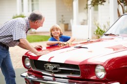 Grandfather teaching his grandson about classic and vintage cars