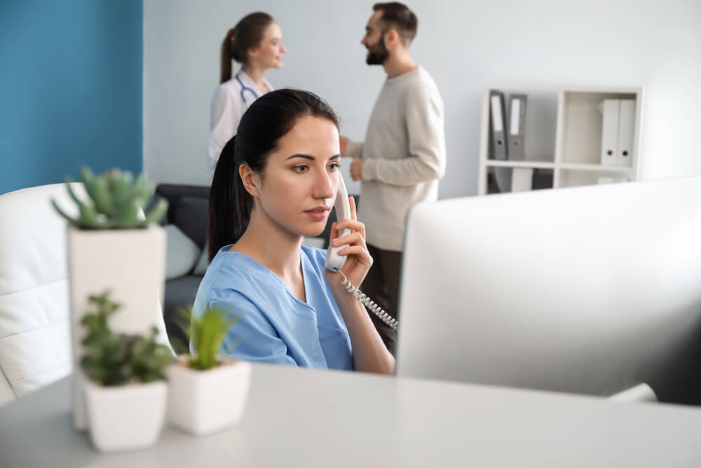 Medical receptionist speaking on the phone