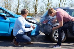 Men looking at cars after a car crash
