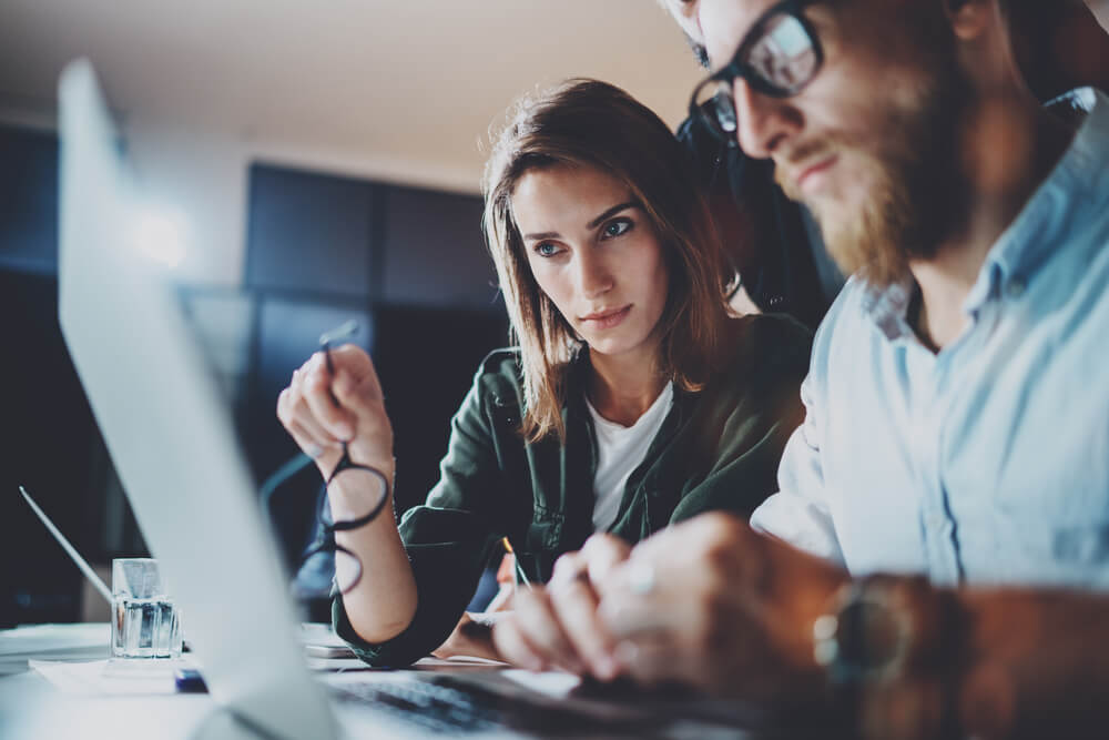 a man and a woman working at a computer