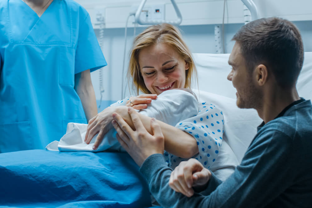A couple with their newborn in the hospital