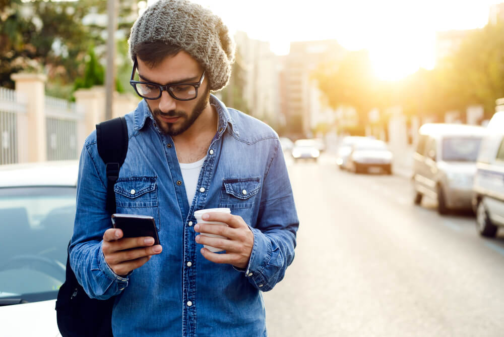 Man using phone to time smart appliances